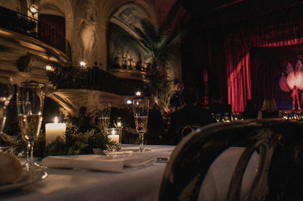 Festive dinner table set with candles, glasses and seasonal greenery in a warm room