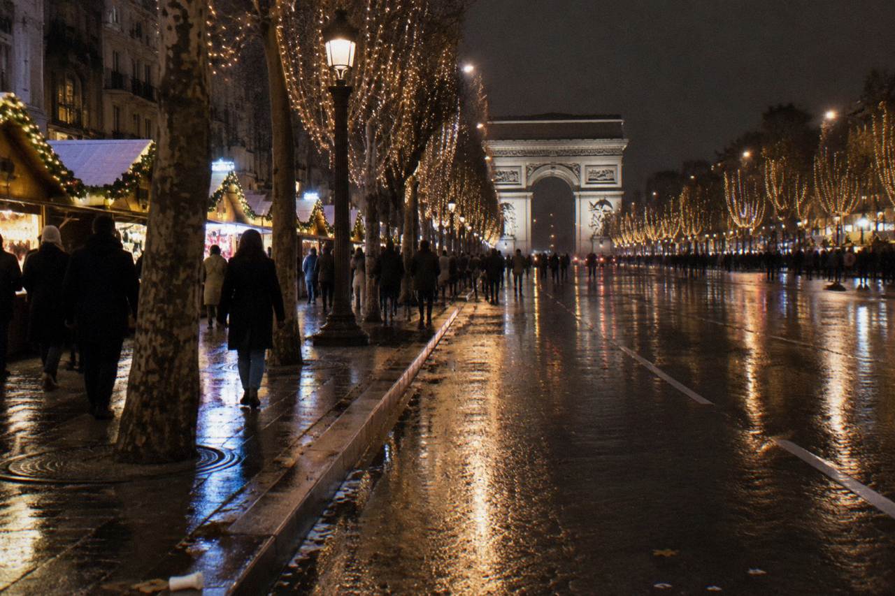 Illuminated Champs-Élysées avenue at night with the Arc de Triomphe glowing at the far end