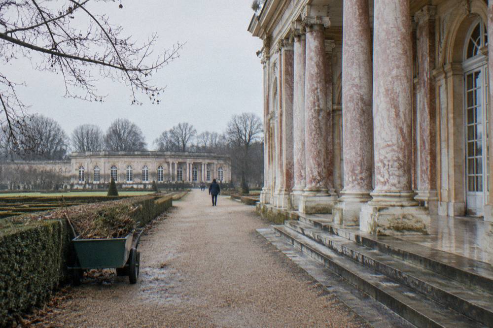 Tree-lined gravel path leading toward the Trianon estate in winter