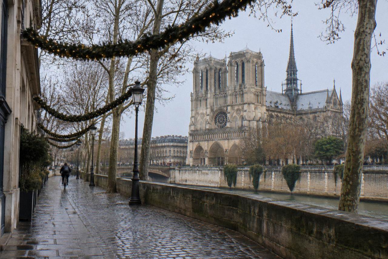 Empty Paris street with holiday garlands strung above the sidewalk in early winter