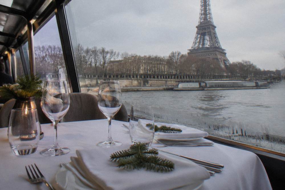 A festively decorated dining deck on a river boat with tables set for a meal