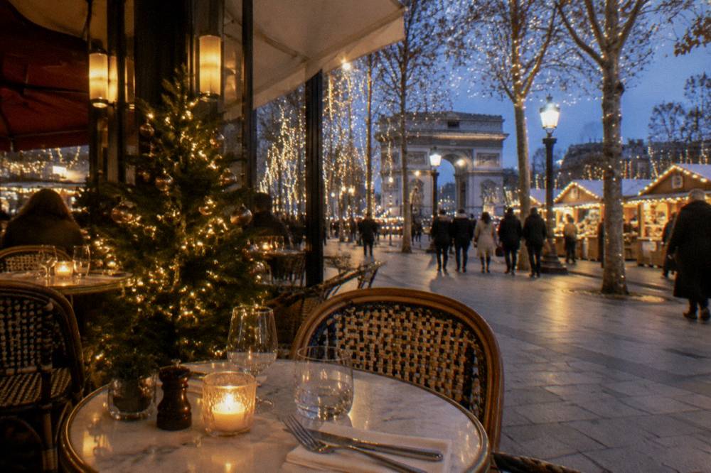 A festive dining room with a decorated tree and candles on set tables