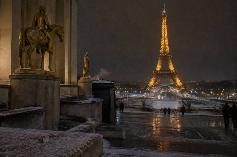The illuminated Eiffel Tower seen across the Seine at night in winter