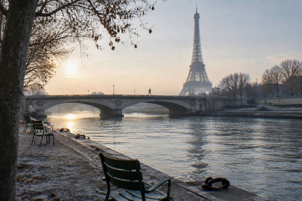 A quiet Paris riverside embankment beside the bridge piers in winter