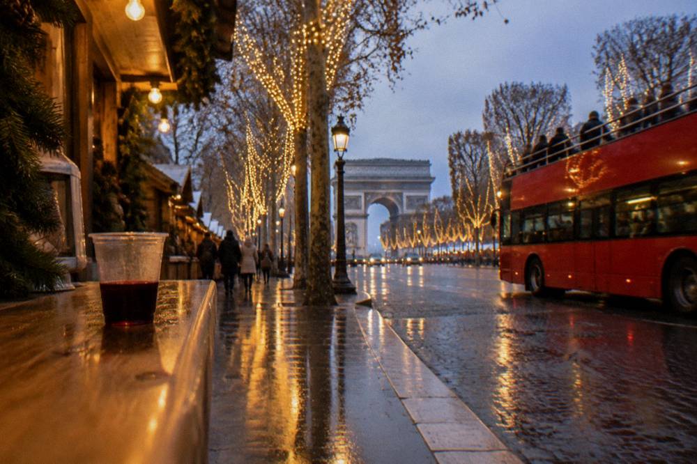 A red open-top double-decker bus on a lit Paris street in the early evening