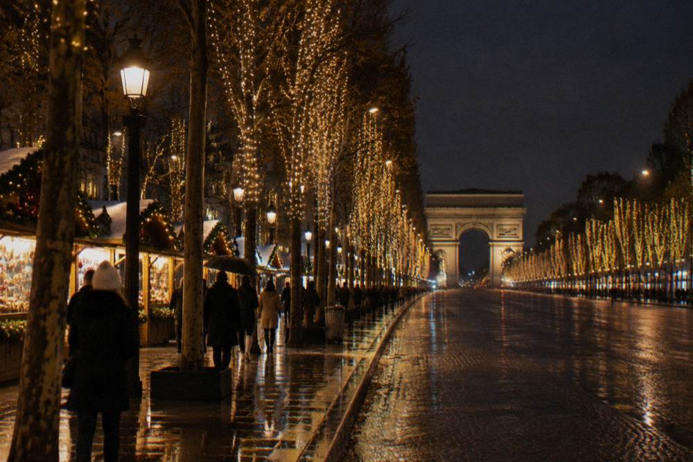 The Champs-Elysees avenue at night with illuminated trees and a festive crowd