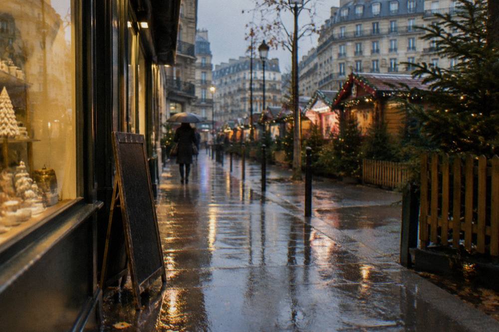 Wet Paris street in late afternoon with lights reflecting on the pavement