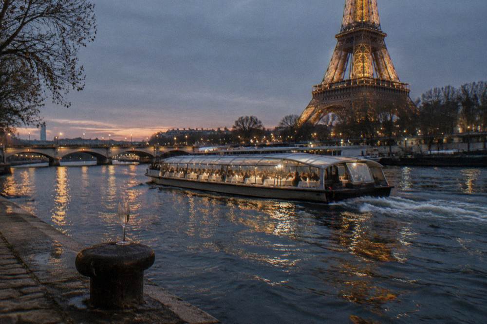 Dinner cruise boat on the Seine at night with city lights reflected on the water