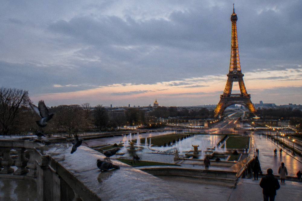 Eiffel Tower glowing after dark above the city skyline