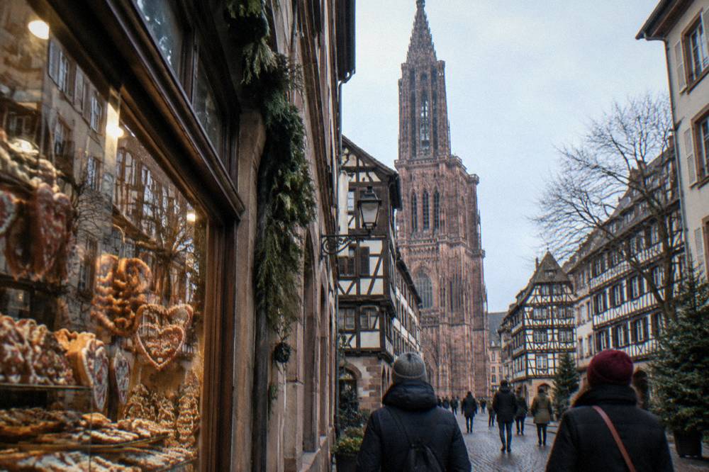 Wooden market chalets with garlands in a square beside a gothic cathedral
