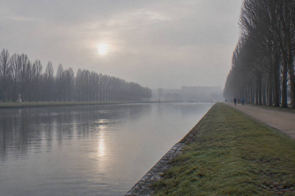 The Versailles gardens in winter with bare trees lining the Grand Perspective toward the horizon